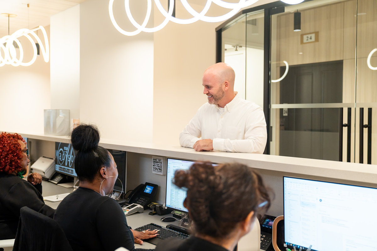 A patient checking in with the friendly front desk team at Madison Dental Group.