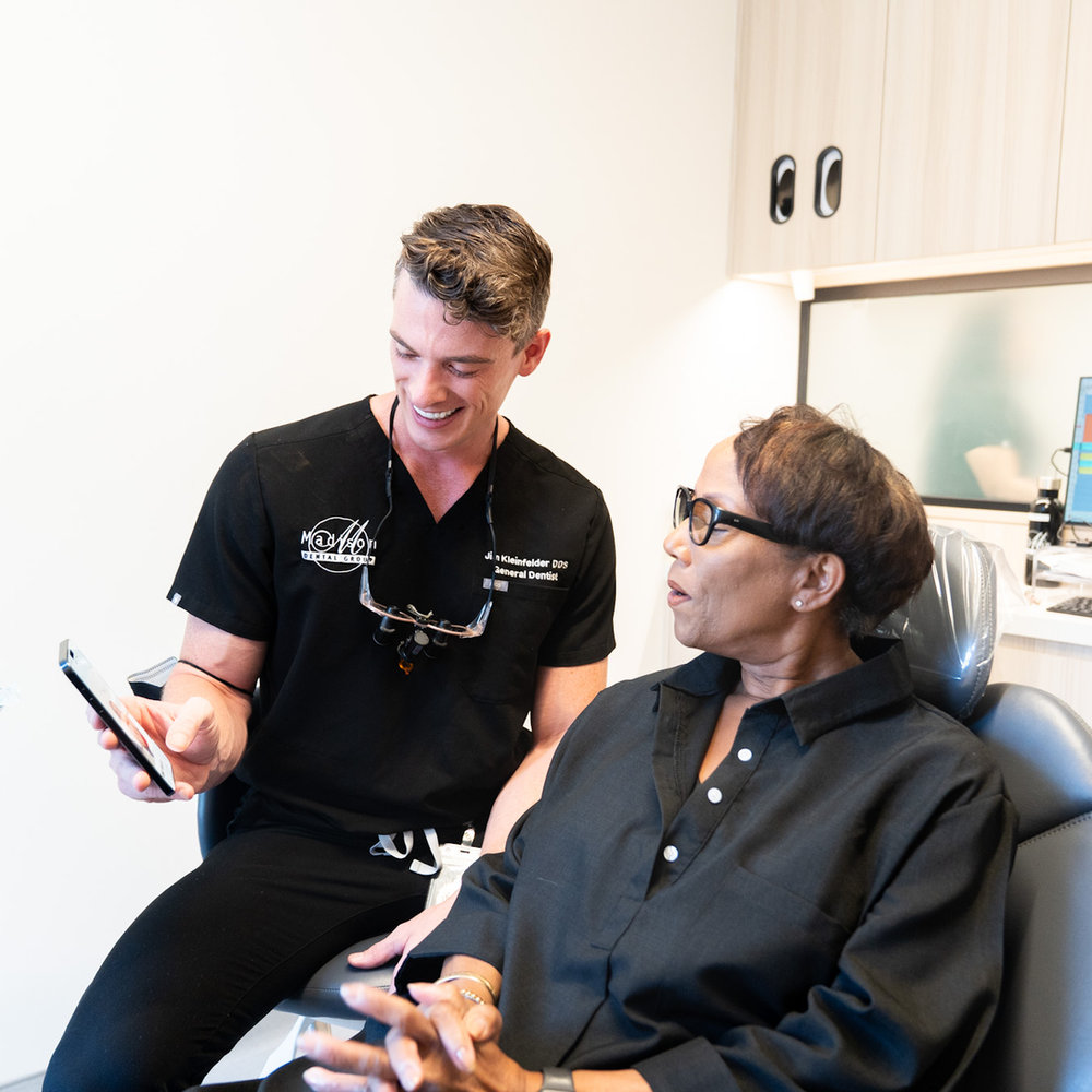 A Madison Dental Group dentist discussing treatment recommendations with a long-standing patient.