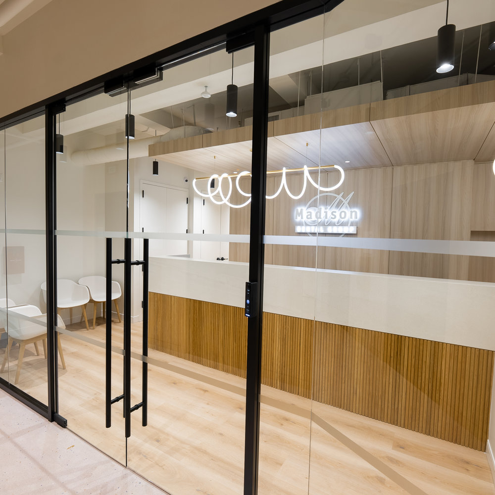 The modern glass entrance of the Madison Dental Group office in New York.